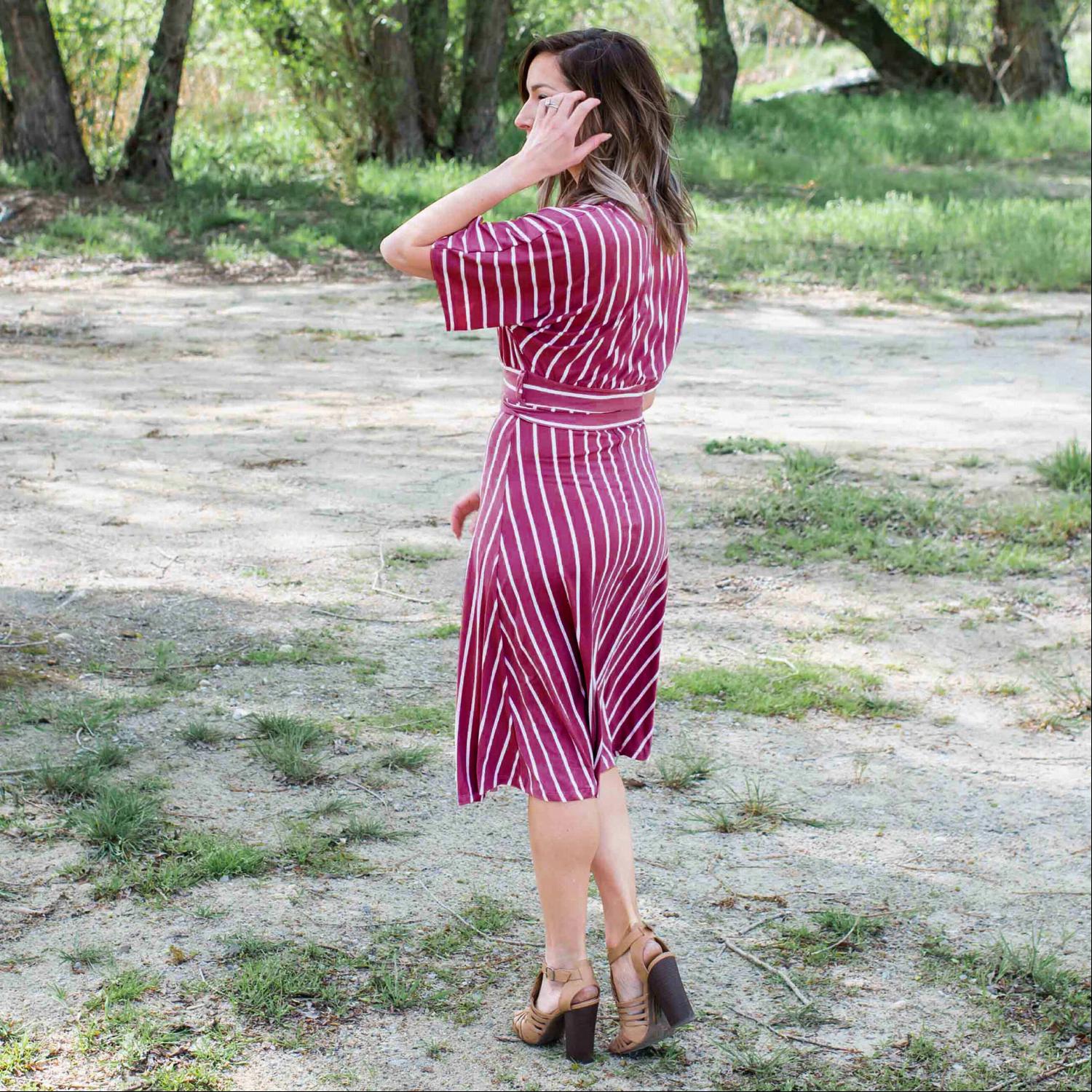 A stylish striped vee neck dress featuring a plunging neckline, self-tie waist, and soft swingy sleeves, perfect for summer outings.