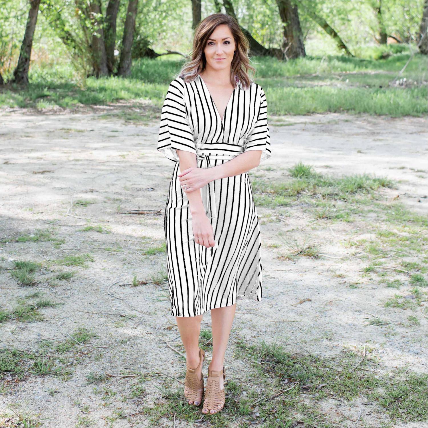 A stylish striped vee neck dress featuring a plunging neckline, self-tie waist, and soft swingy sleeves, perfect for summer outings.