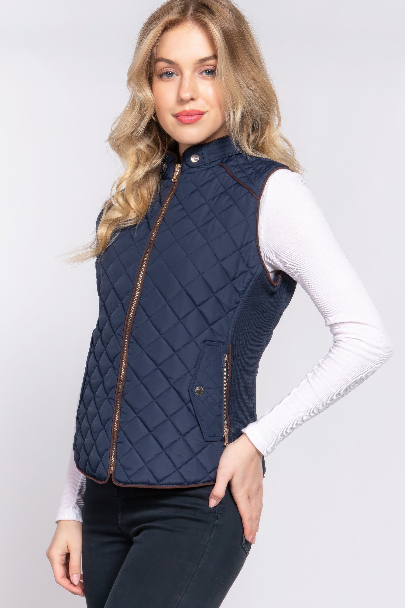 A stylish Suede Piping Quilted Padding Vest in Pale Taupe color, featuring suede piping details and front pockets, perfect for layering.