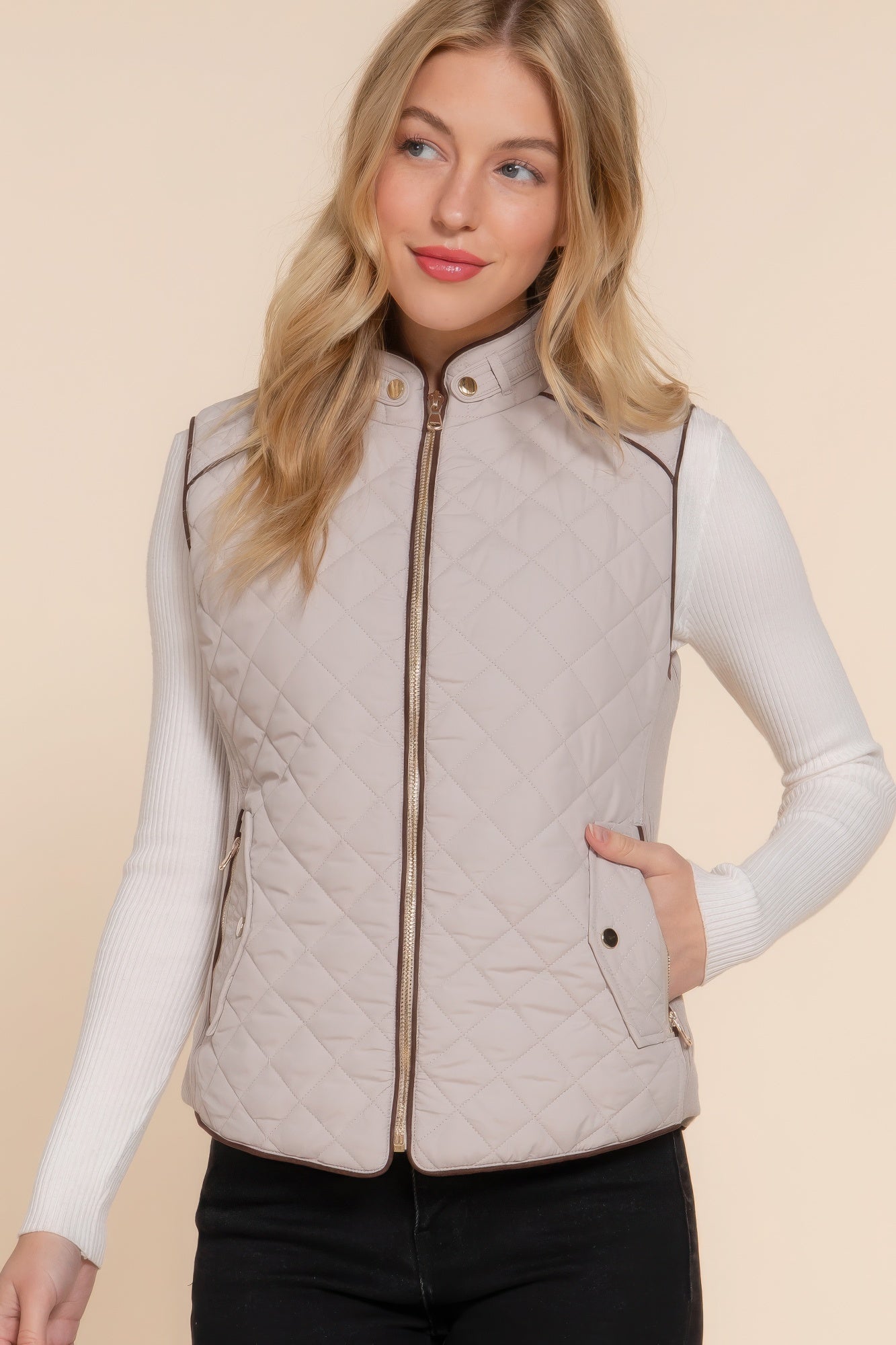 A stylish Suede Piping Quilted Padding Vest in Pale Taupe color, featuring suede piping details and front pockets, perfect for layering.