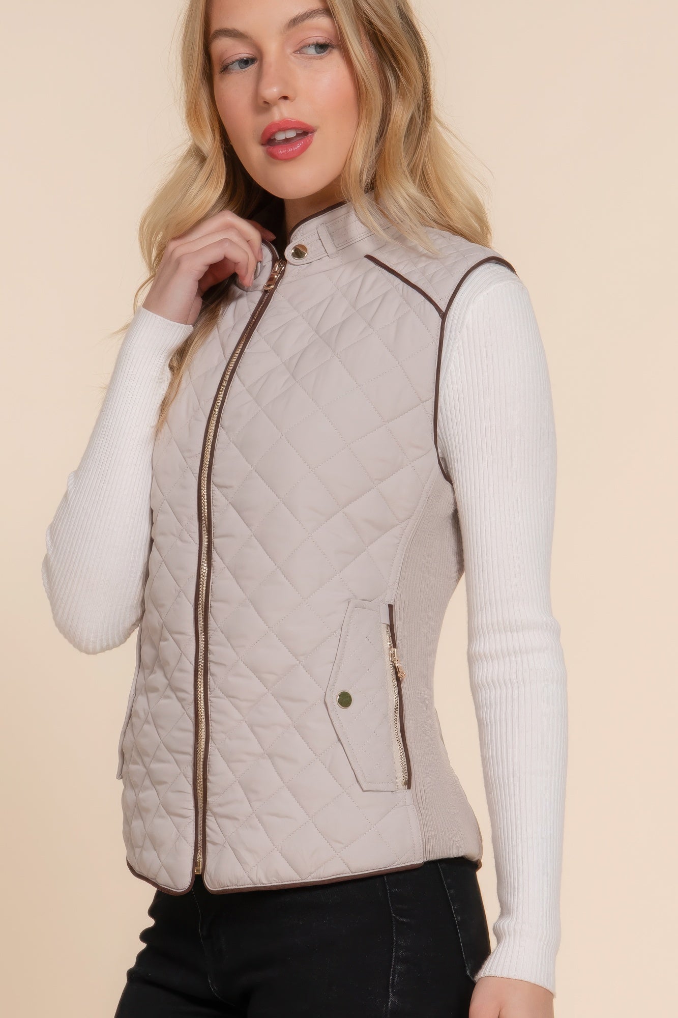 A stylish Suede Piping Quilted Padding Vest in Pale Taupe color, featuring suede piping details and front pockets, perfect for layering.