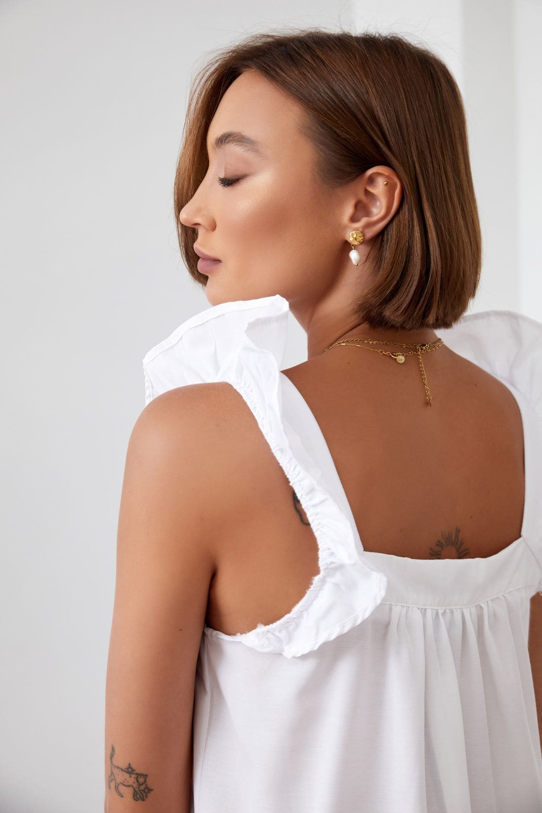 Woman wearing ruffled white top.