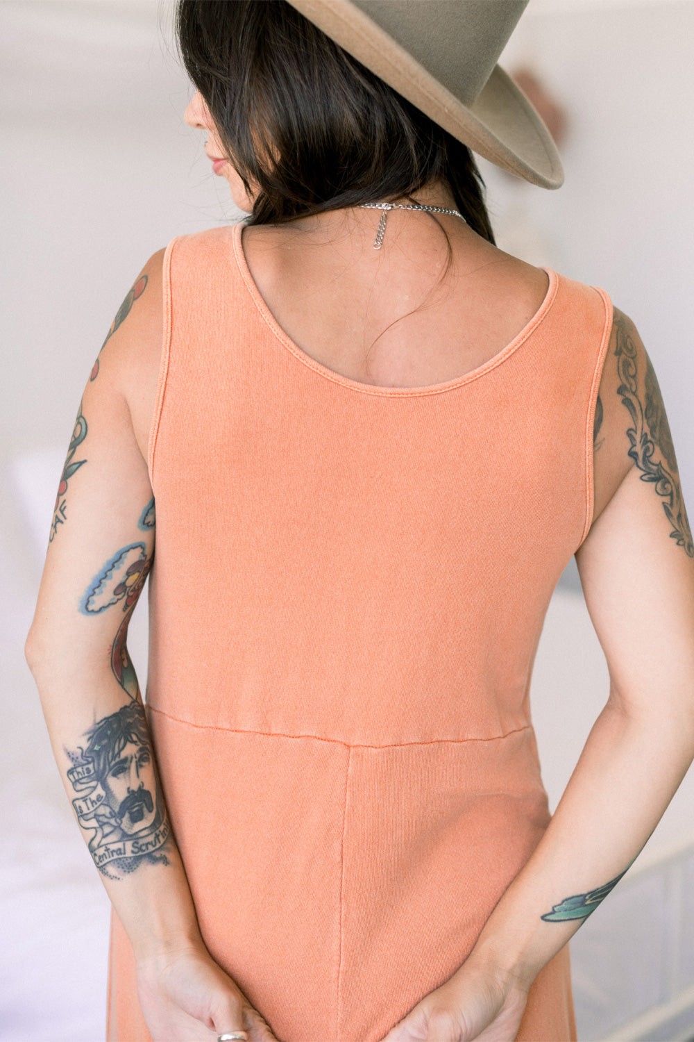 A stylish Sunset Jumpsuit featuring a waist-defining seam, wide legs, and v-neck detailing, available in Washed Black, Sand, and Persimmon colors.