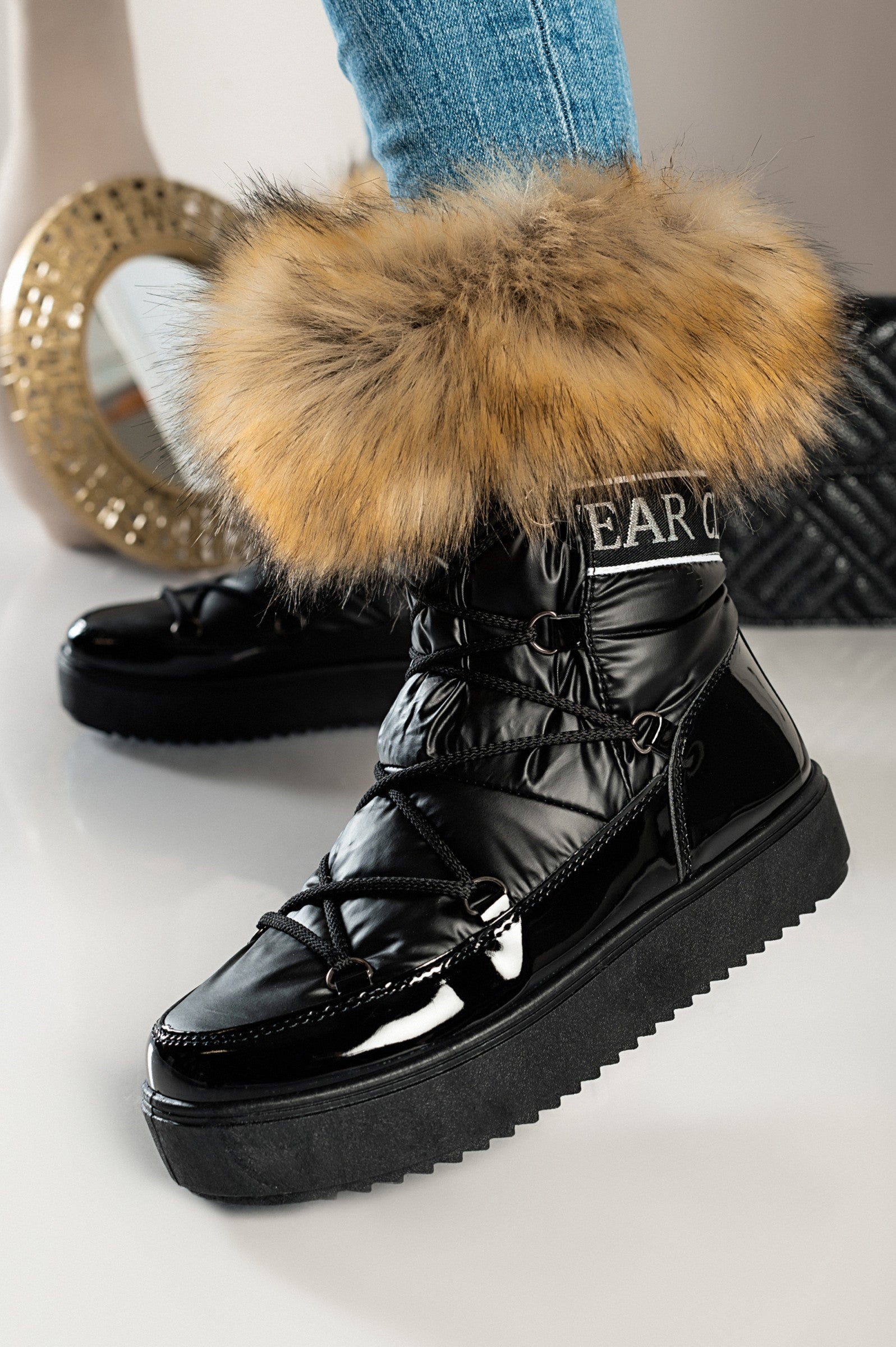 Sutera faux fur ankle boots in black with raised sole and lace-up fastening, featuring a stylish round tip and elegant faux fur detail.