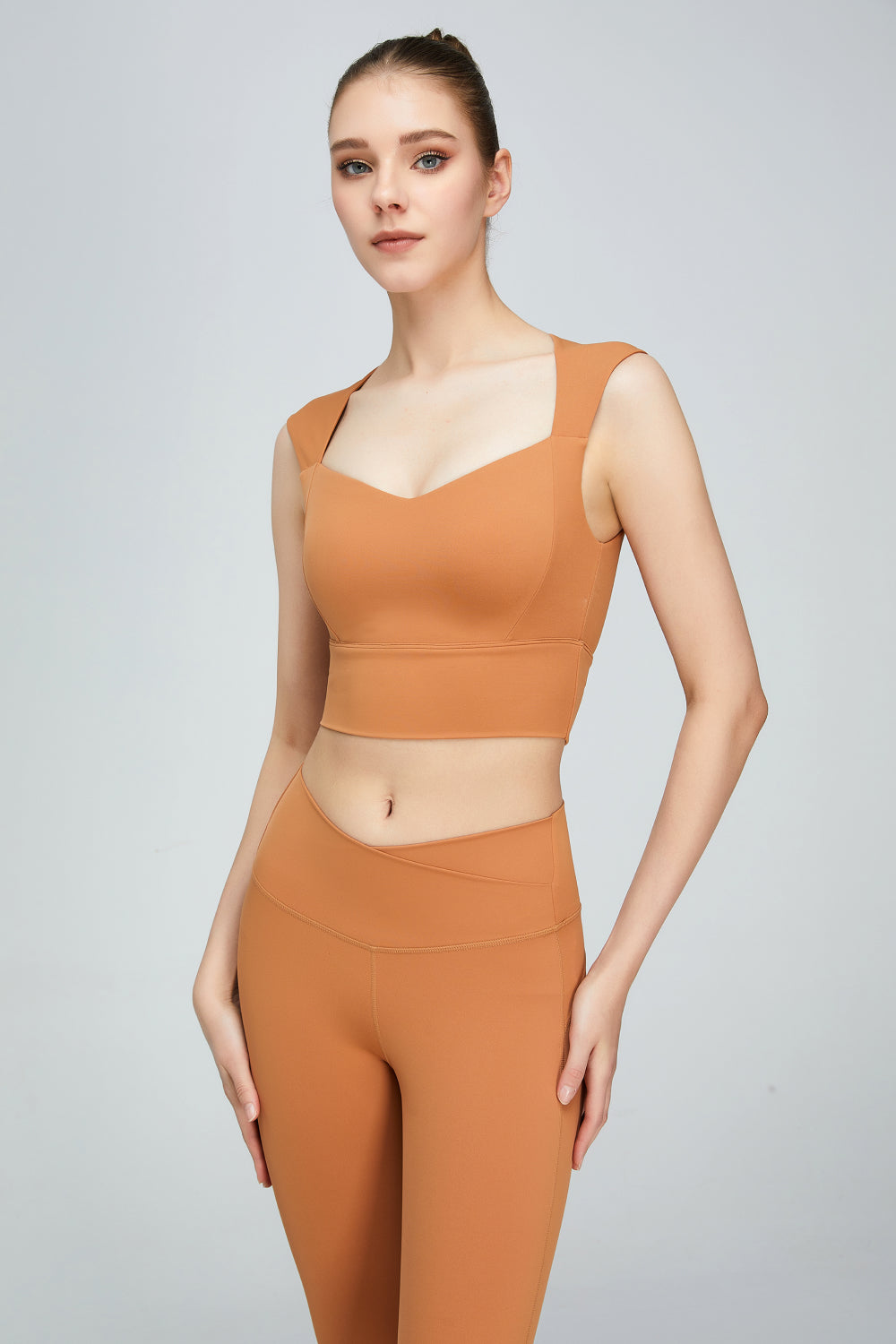 A stylish sweat absorbing sleeveless sports bra in solid color, featuring a Queen Anne neckline and unremovable padding, perfect for yoga and active wear.