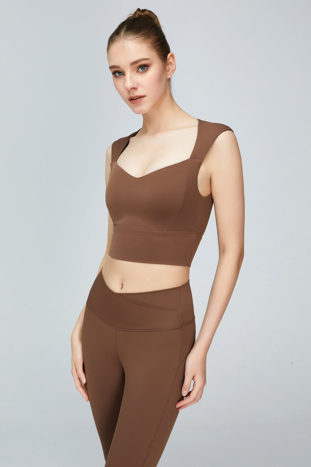 A stylish sweat absorbing sleeveless sports bra in solid color, featuring a Queen Anne neckline and unremovable padding, perfect for yoga and active wear.