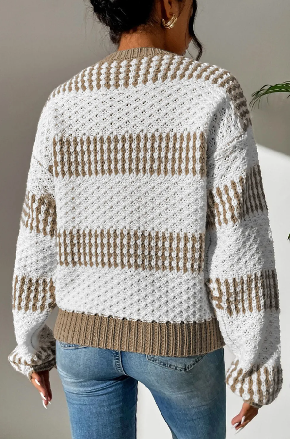 Two-tone multicolor sweater featuring a loose fit, long sleeves, and a round neckline, made from soft acrylic material.