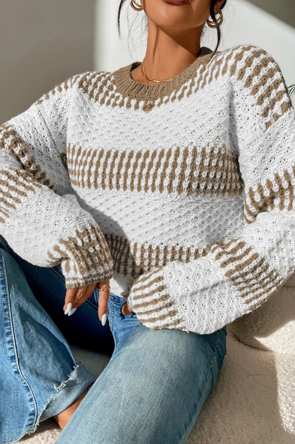 Two-tone multicolor sweater featuring a loose fit, long sleeves, and a round neckline, made from soft acrylic material.