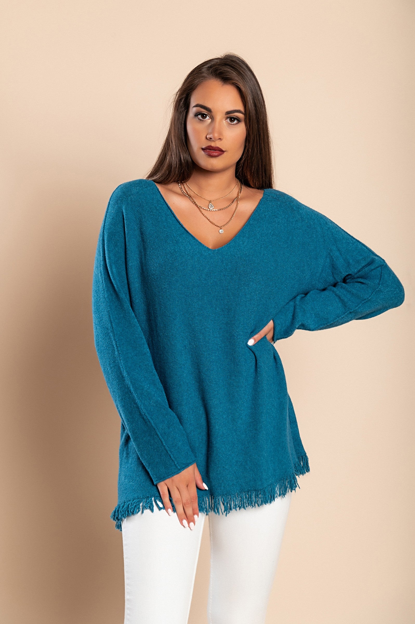 A fashionable petrol sweater with fringes, featuring a V-neckline and long sleeves, made from soft knitwear.