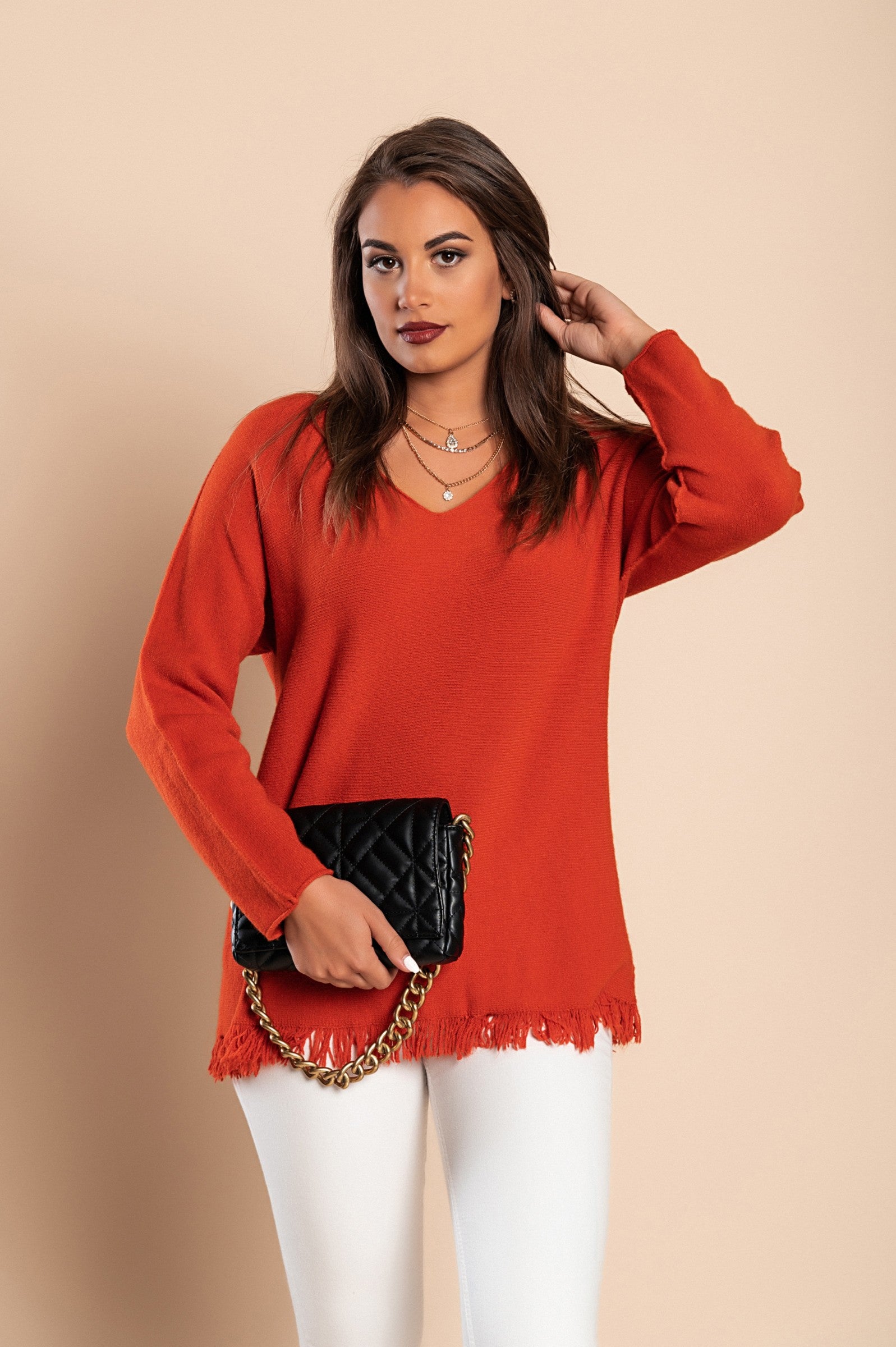 A fashionable brick sweater with tassels, featuring a V-neckline and long sleeves, made from soft knitwear.