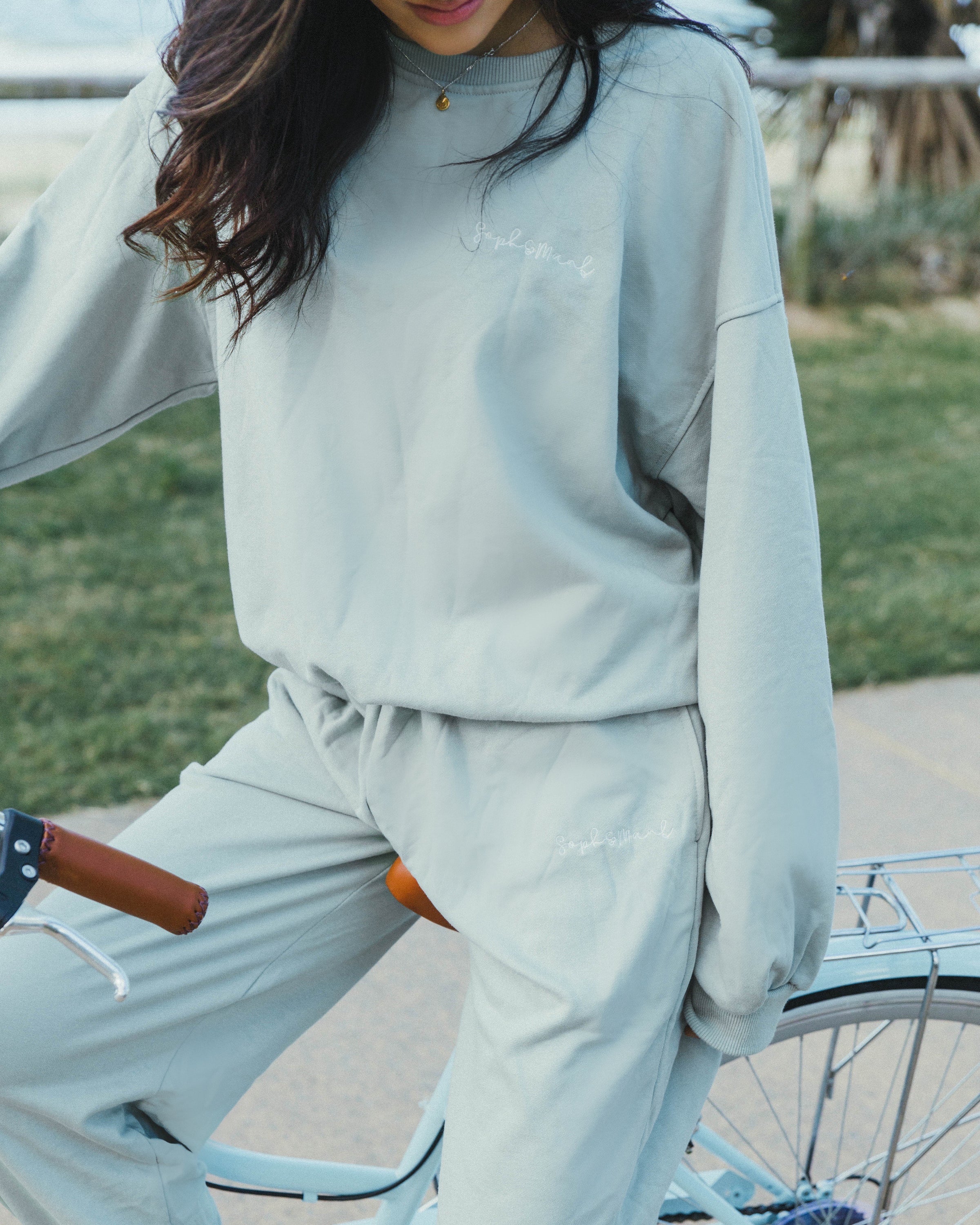 Sage green sweatshirt displayed on a model, showcasing its soft fabric and stylish design.