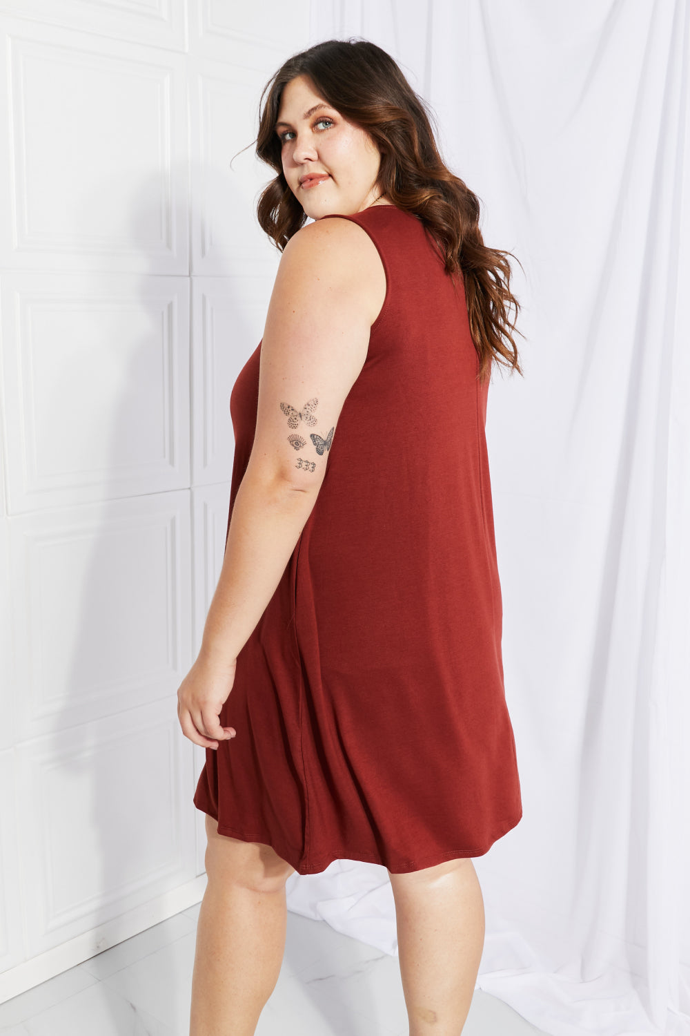 A stylish sleeveless dress in a solid color, featuring a flowy shift cut and pockets, perfect for spring and summer wear.