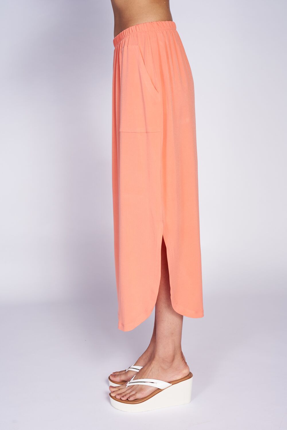 Sydney Pocket Skirt featuring a curved hem, pockets, and a wide elastic waistband, perfect for stylish comfort.