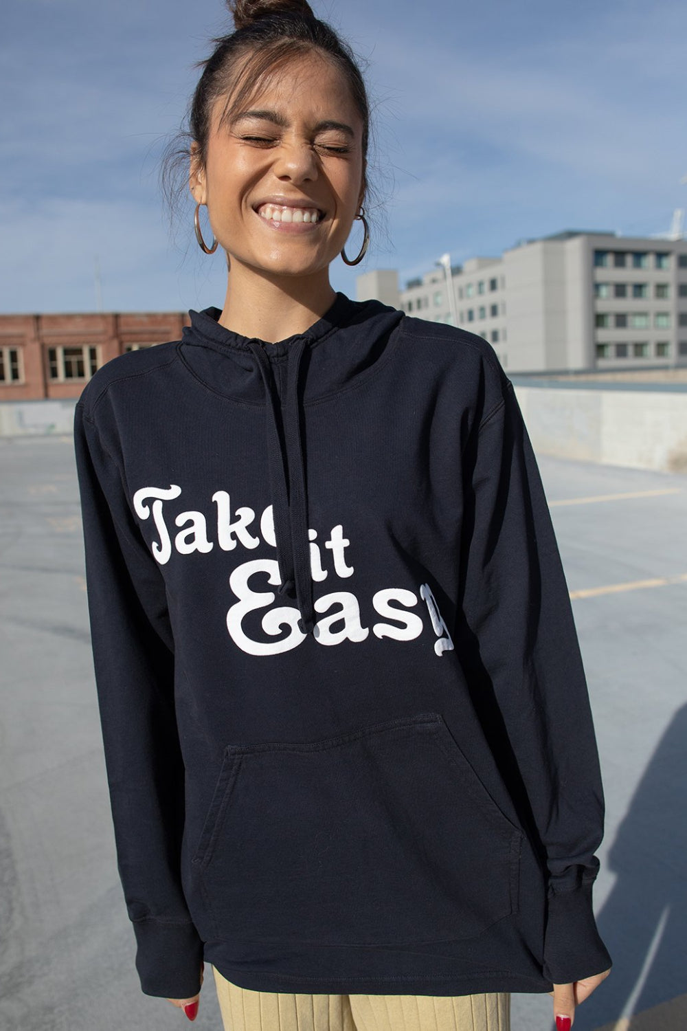 Black Take It Easy Pullover Hoodie with front pockets and cuffed sleeves, featuring a stylish graphic.