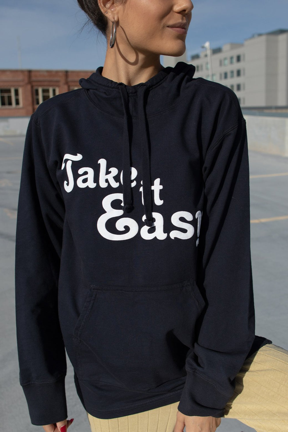 Black Take It Easy Pullover Hoodie with front pockets and cuffed sleeves, featuring a stylish graphic.