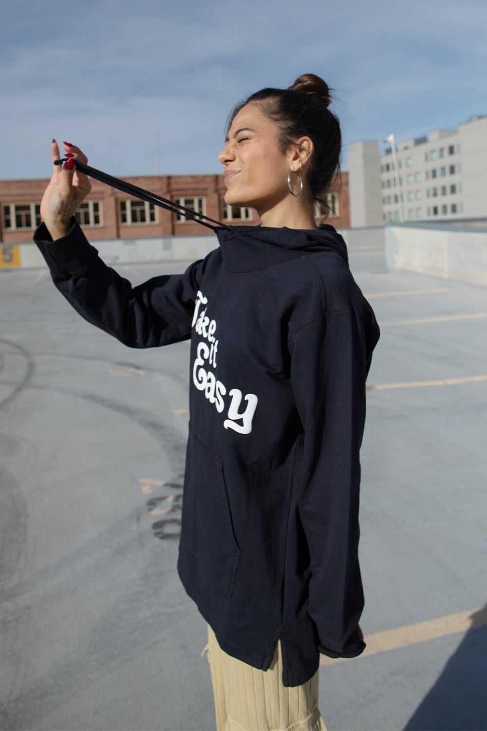 Black Take It Easy Pullover Hoodie with front pockets and cuffed sleeves, featuring a stylish graphic.