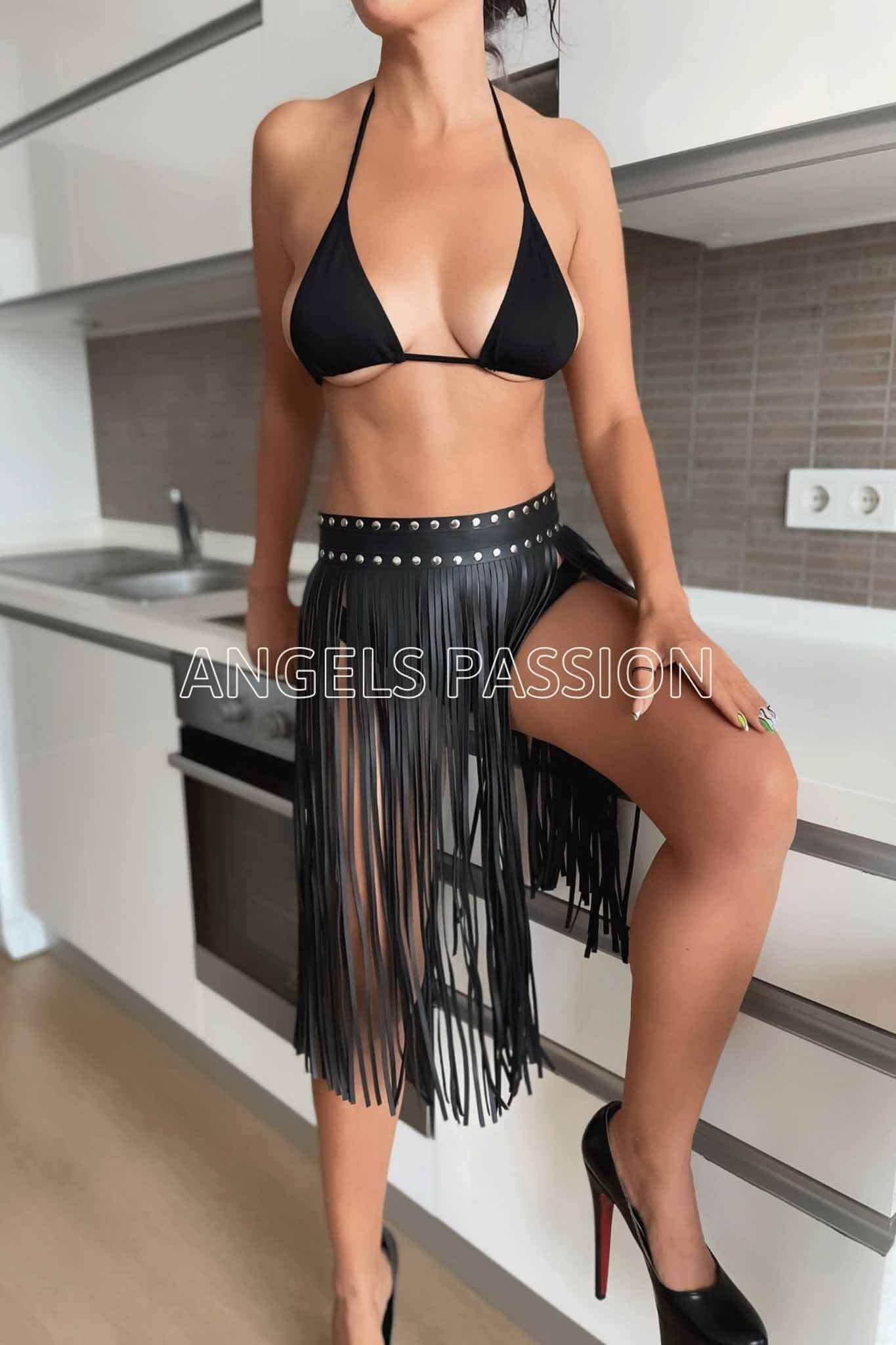 A stylish tassel fringe maxi skirt belt made of faux leather, featuring a hook and eye closure and available in black and red colors.