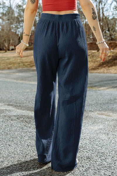 A pair of stylish Texture Tied Wide Leg Pants in a soft cotton fabric, featuring a tied waist design and a wide-leg silhouette.