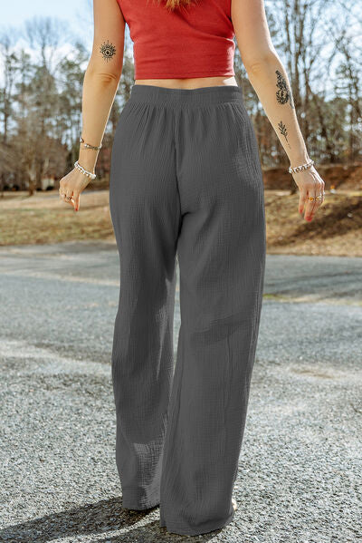 A pair of stylish Texture Tied Wide Leg Pants in a soft cotton fabric, featuring a tied waist design and a wide-leg silhouette.