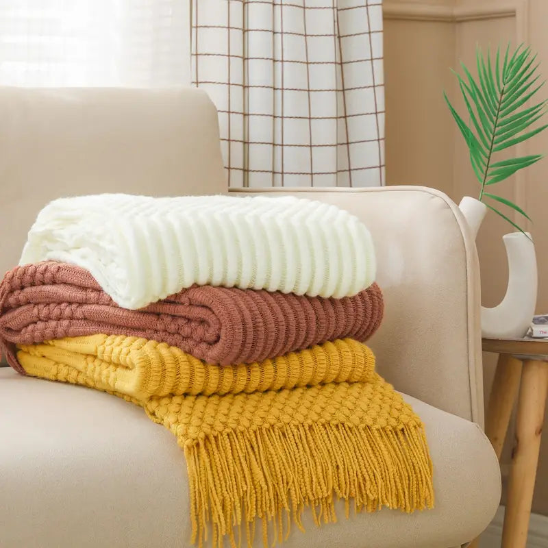 A soft, textured knit throw blanket in a cozy setting, perfect for snuggling.