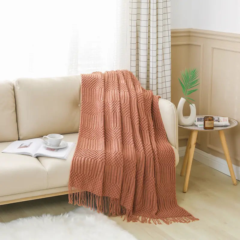 A soft, textured knit throw blanket in a cozy setting, perfect for snuggling.