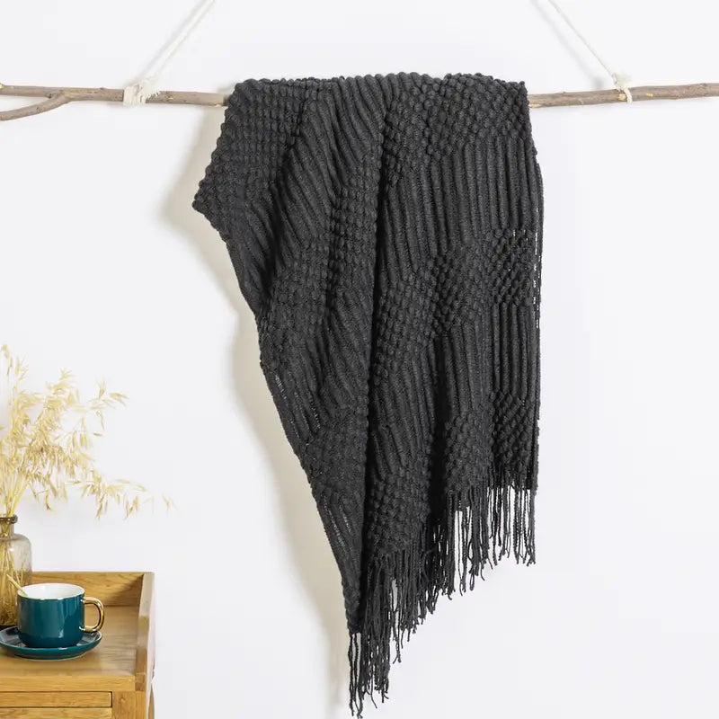 A soft, textured knit throw blanket in a cozy setting, perfect for snuggling.