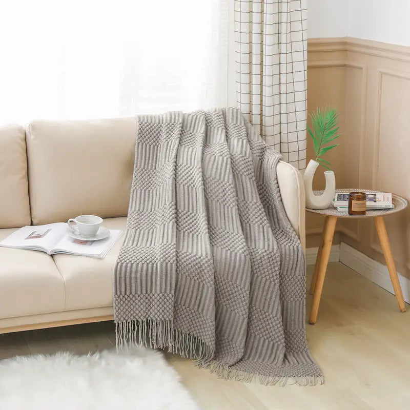 A soft, textured knit throw blanket in a cozy setting, perfect for snuggling.