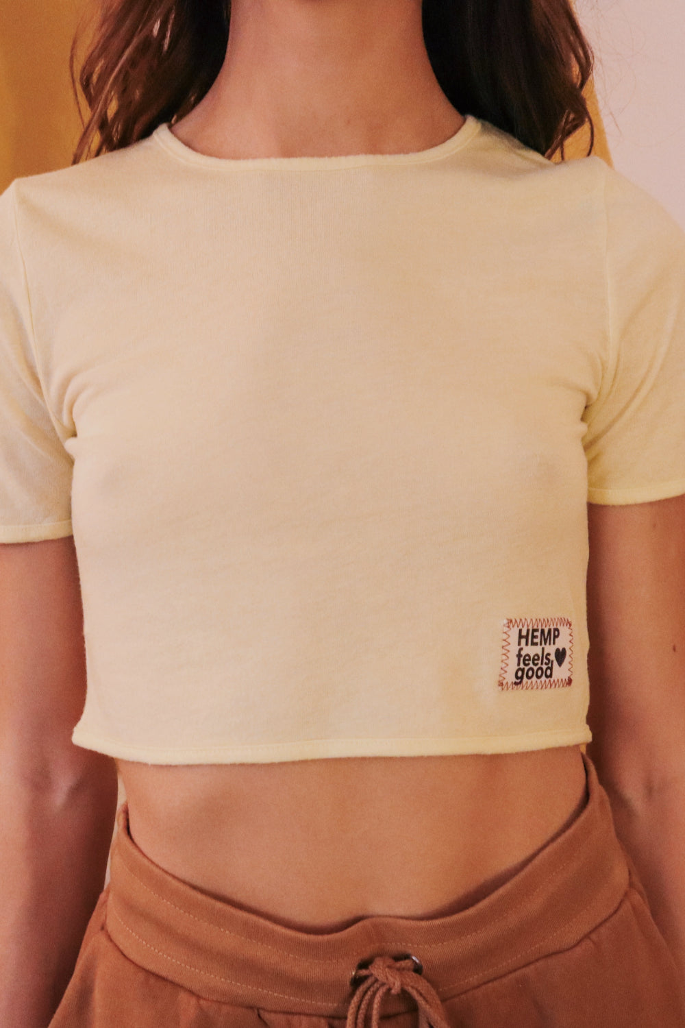 The Ana crop top in vibrant yellow, made from hemp and organic cotton, showcasing its stylish square design and comfortable fit.