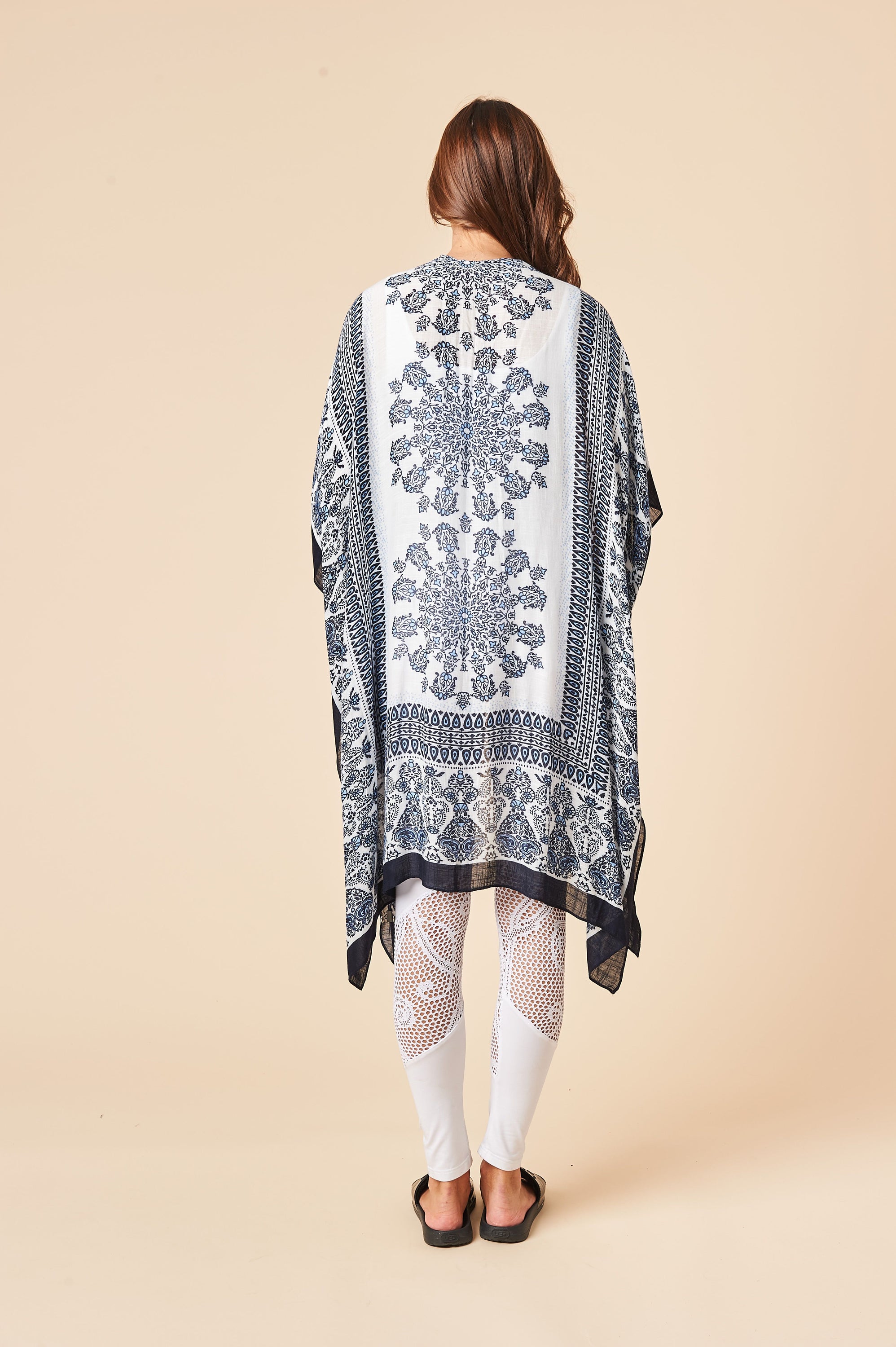 A beautiful blue and white Bohemian kimono, featuring a soft viscose blend fabric, side slits, and a flowing silhouette, perfect for stylish layering.