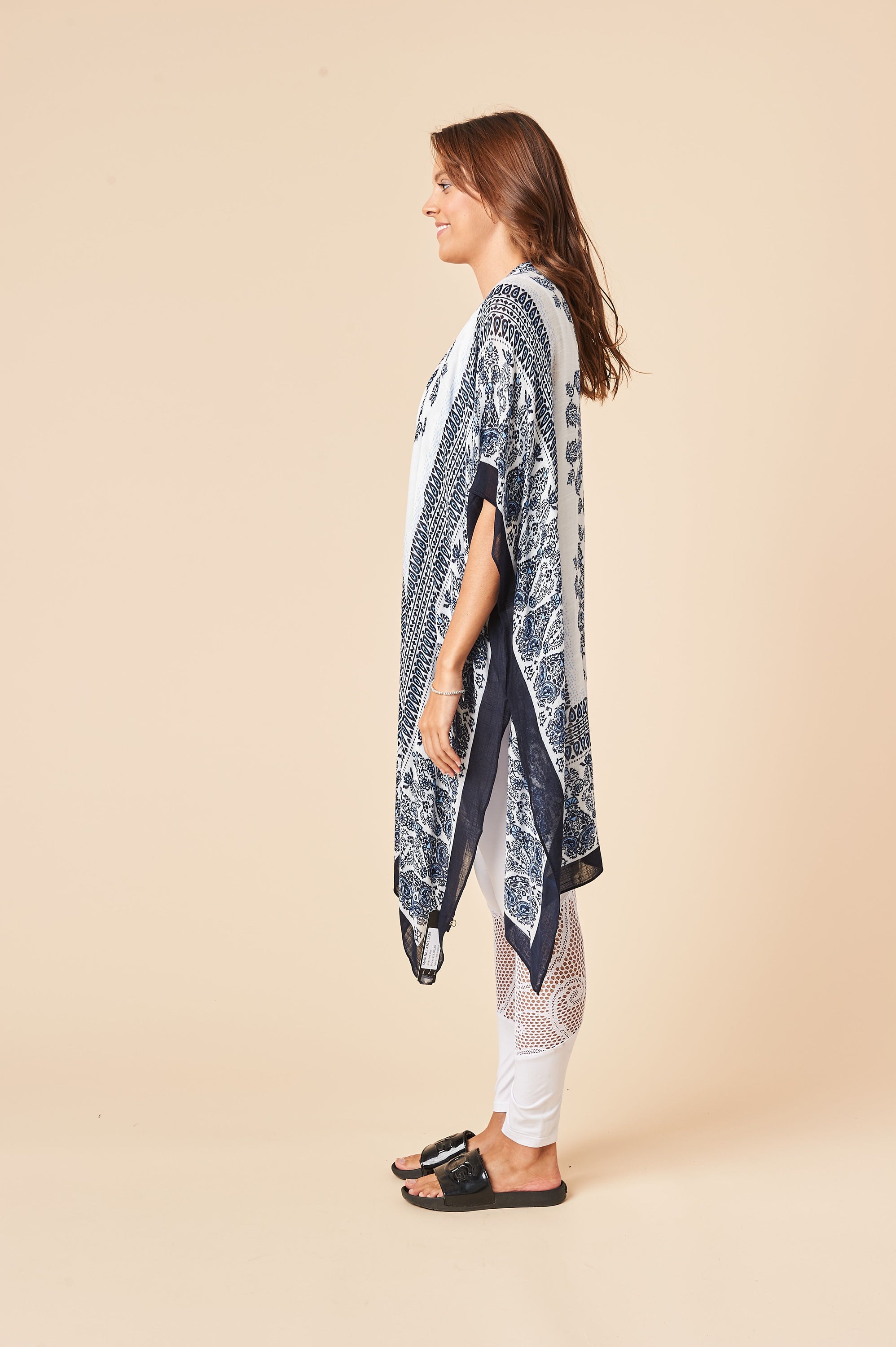 A beautiful blue and white Bohemian kimono, featuring a soft viscose blend fabric, side slits, and a flowing silhouette, perfect for stylish layering.