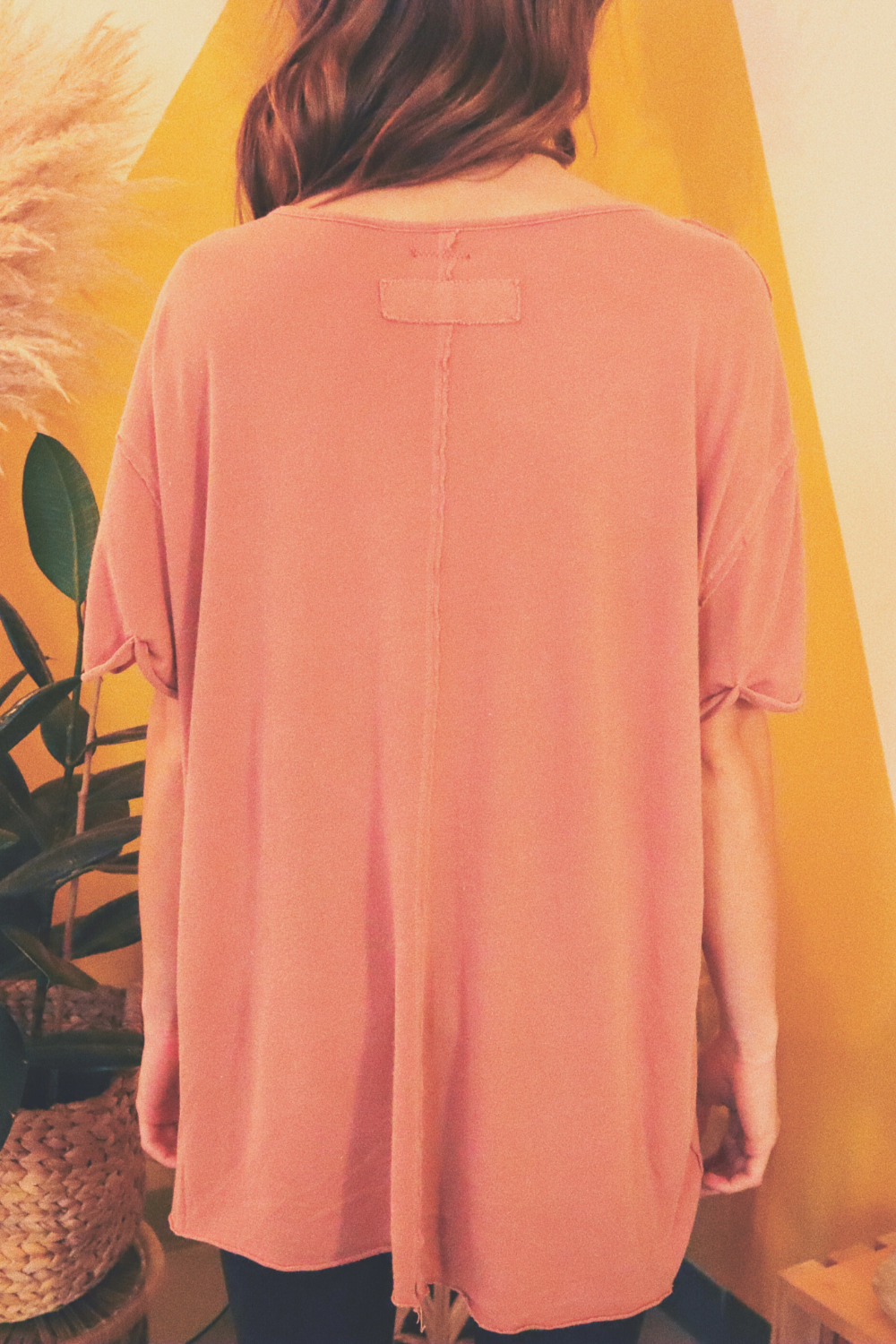 The Carli oversized slouchy tee in pink, featuring a pocket, rolled sleeves, and a back seam detail.