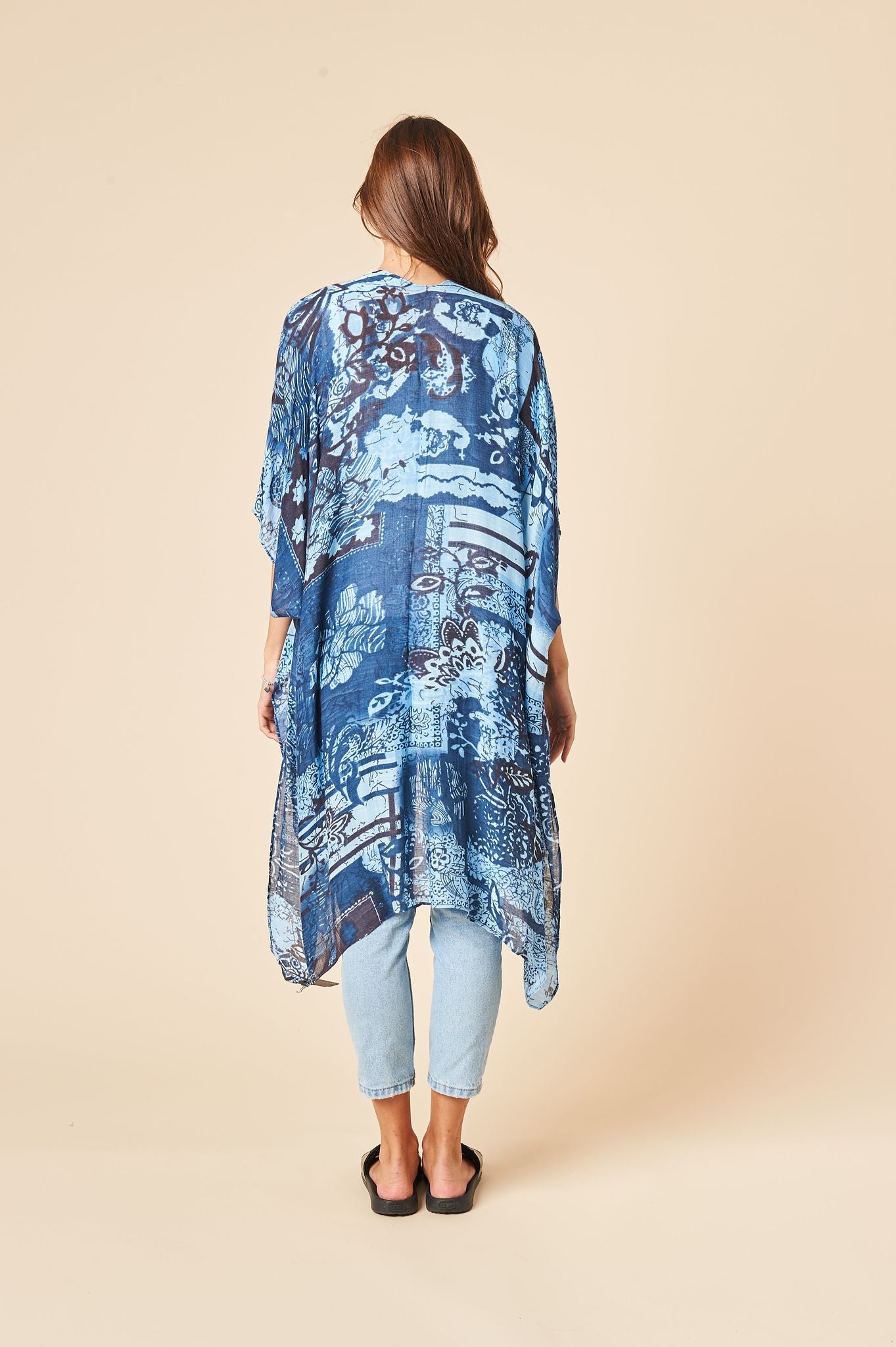 A beautiful whitish blue kimono with a cloudy print, featuring side slits and a luxurious soft fabric, perfect for layering or lounging.