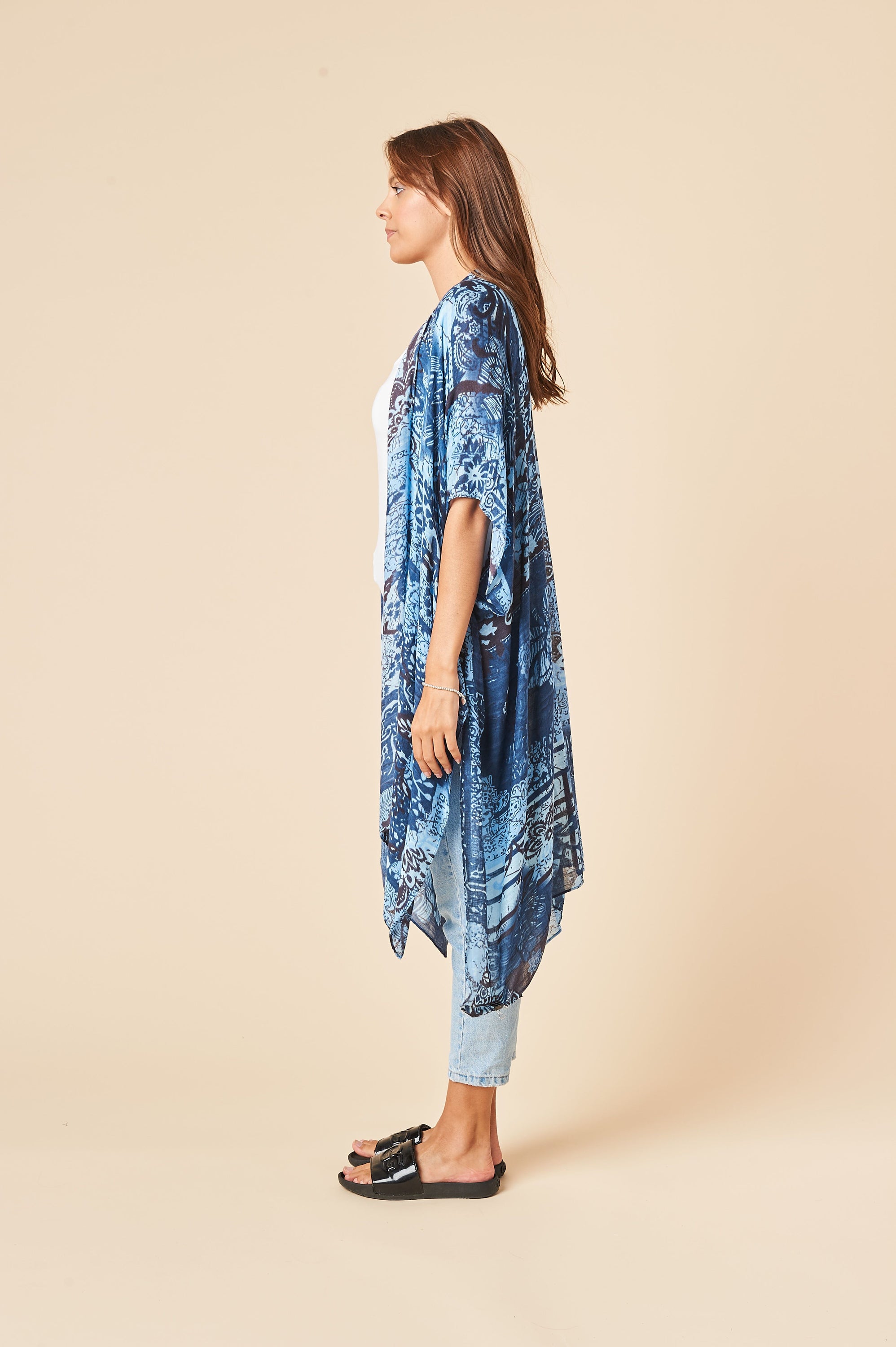 A beautiful whitish blue kimono with a cloudy print, featuring side slits and a luxurious soft fabric, perfect for layering or lounging.