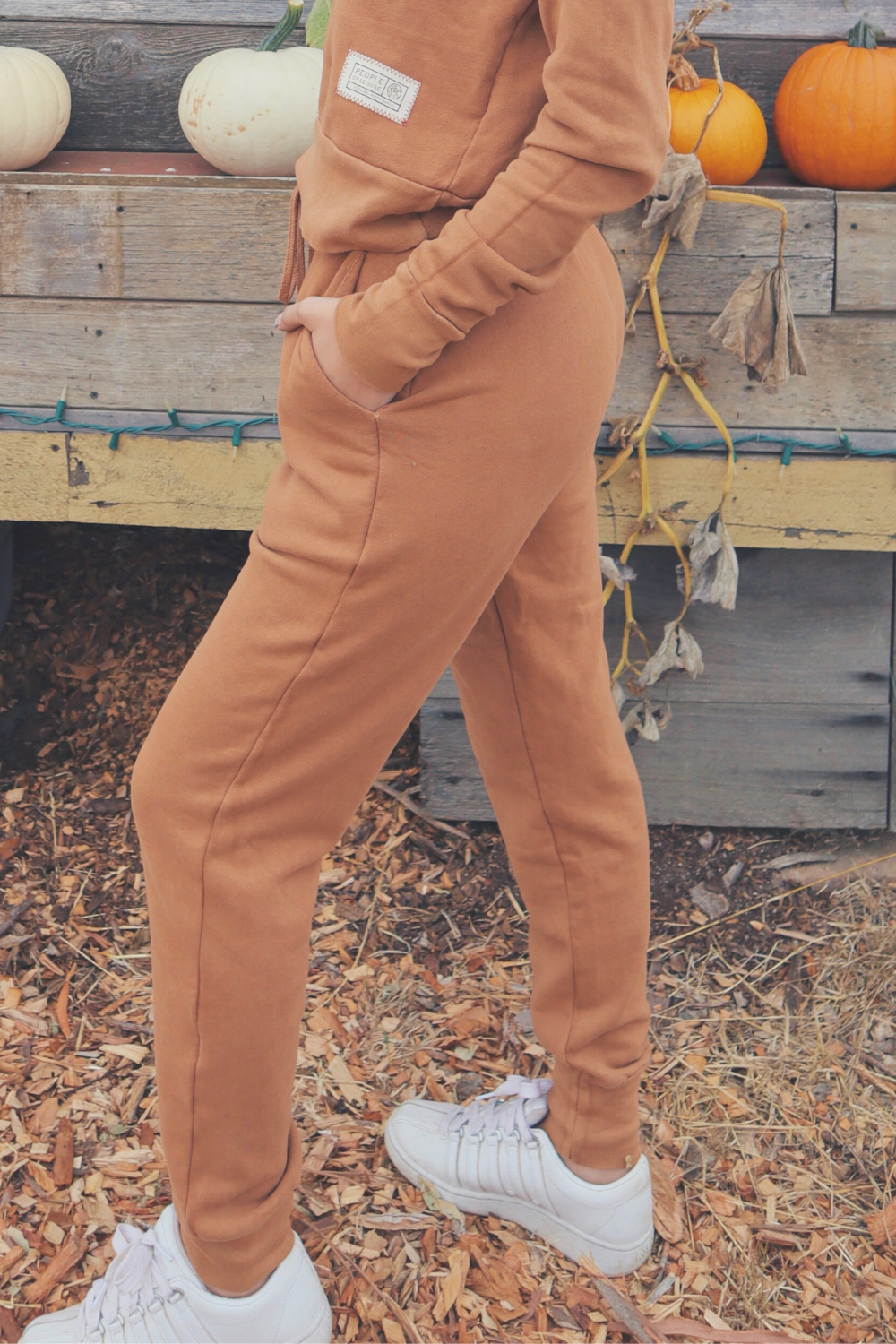 A pair of high-waisted Daybreak Joggers made from 100% organic cotton, featuring elastic ankle details and pockets, displayed in a stylish setting.