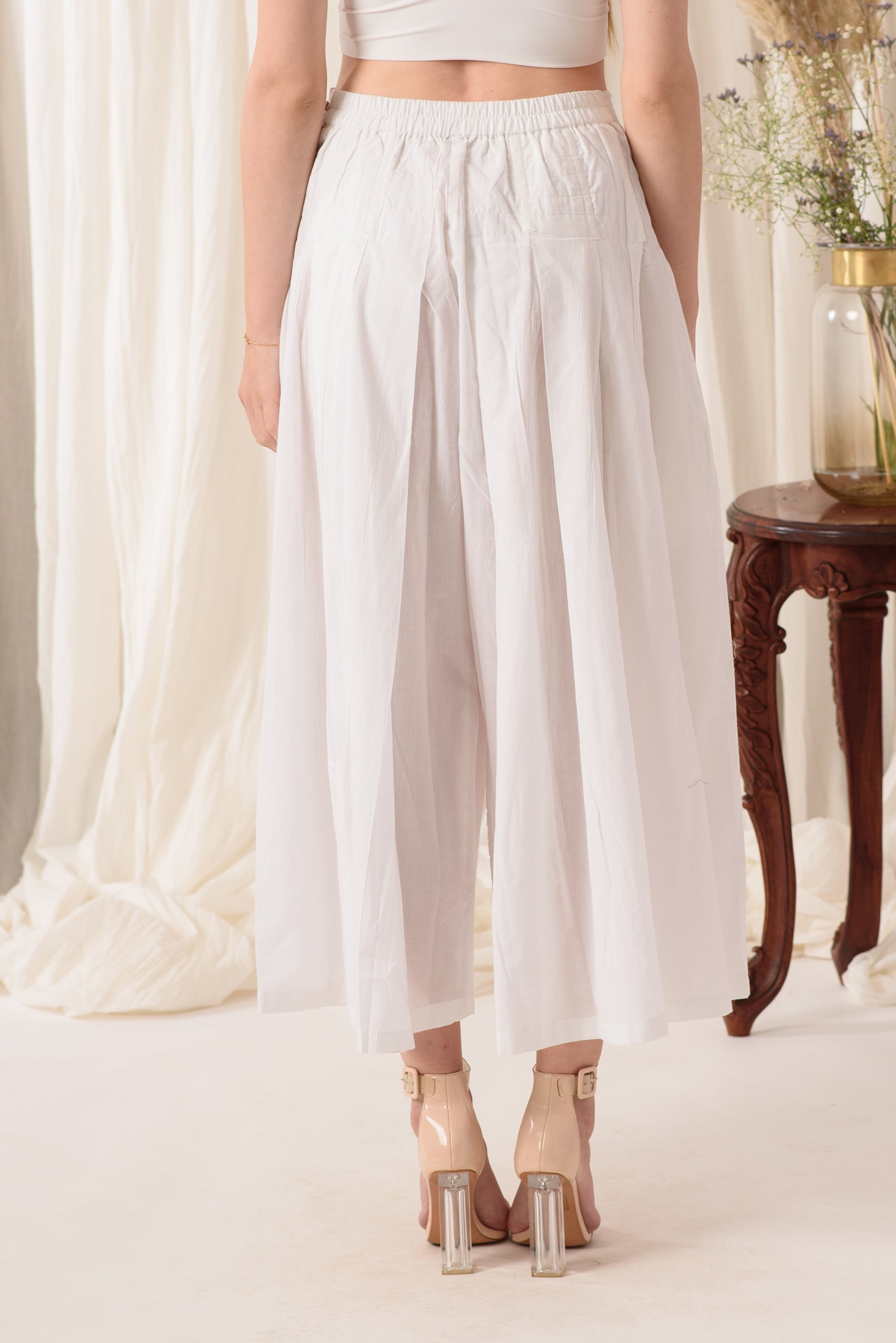 A pair of high-waisted flared pants in ivory white, showcasing a soft fabric and stylish design, perfect for everyday wear.