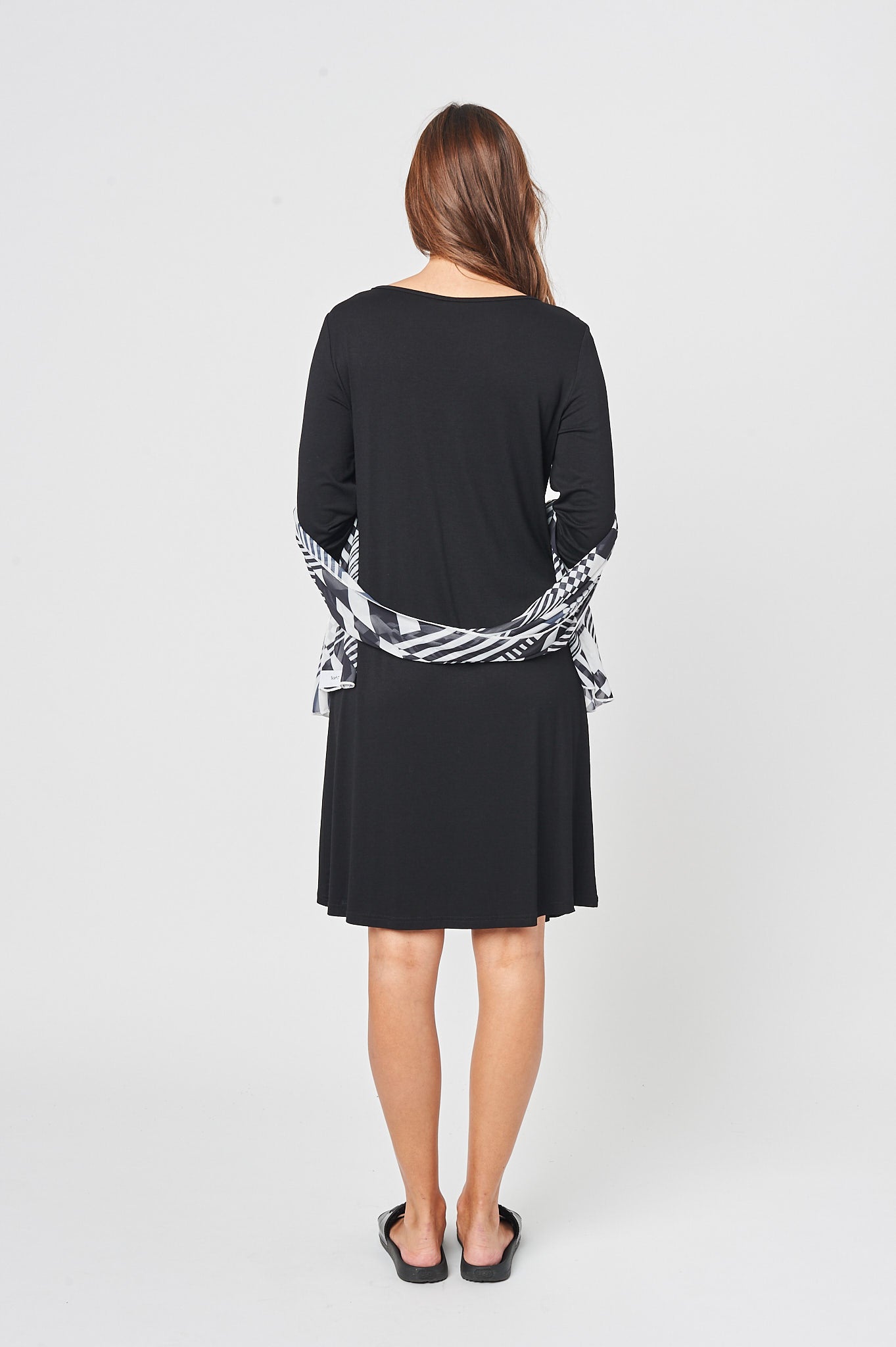 The Feel Good Pleated Dress in Charcoal Black featuring a soft fabric, mid-length design, and a stylish chiffon scarf.