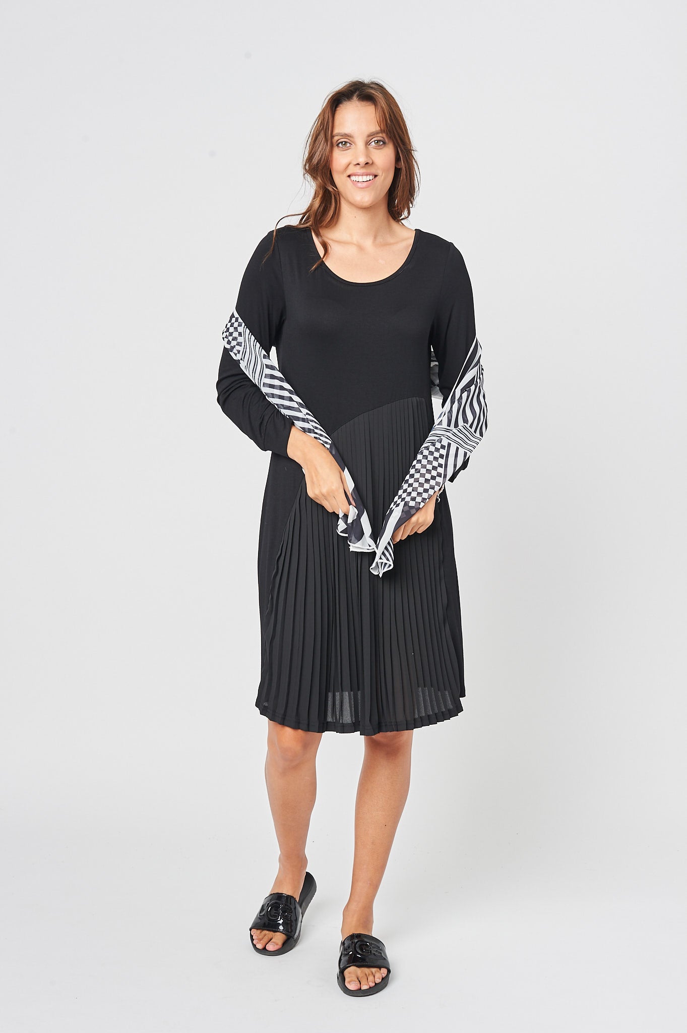 The Feel Good Pleated Dress in Charcoal Black featuring a soft fabric, mid-length design, and a stylish chiffon scarf.