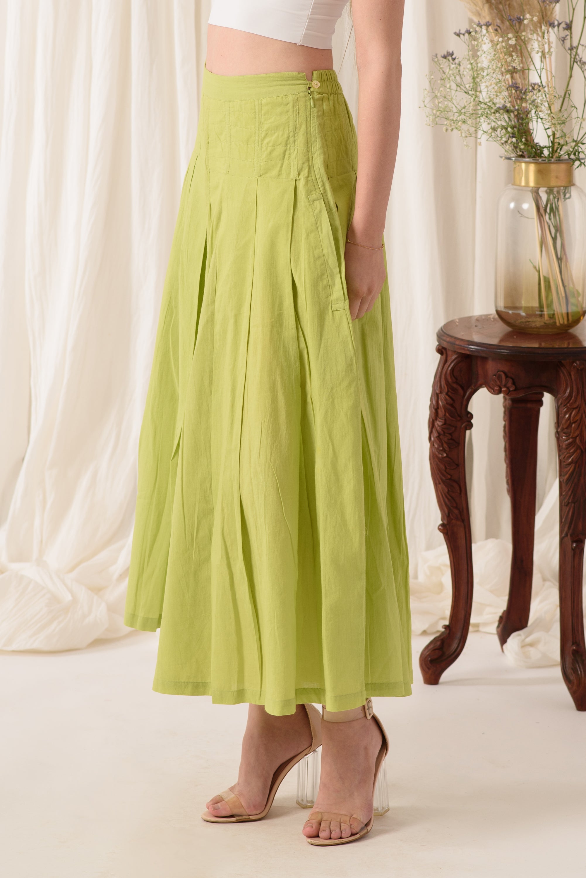 High-waisted flared pants in green, made from soft cotton fabric, showcasing a stylish and comfortable design.