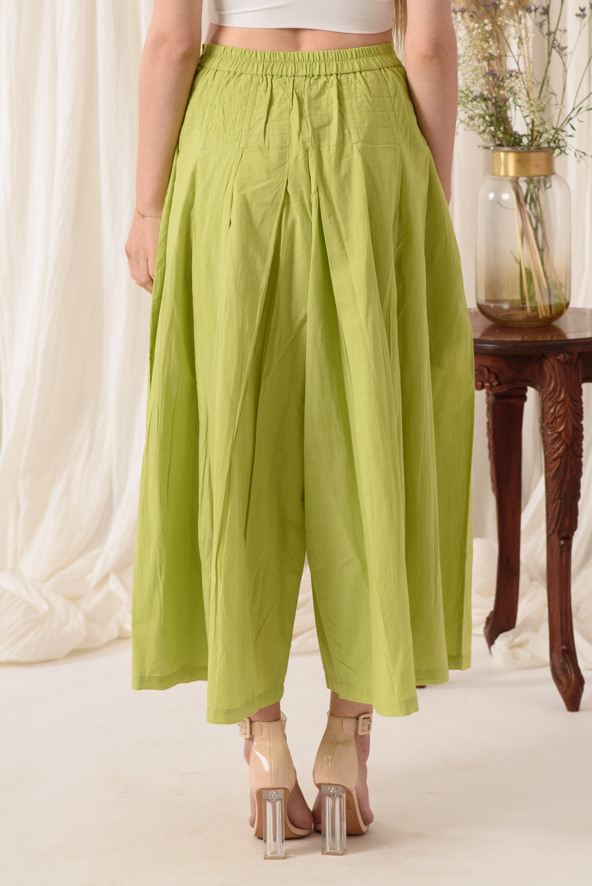 High-waisted flared pants in green, made from soft cotton fabric, showcasing a stylish and comfortable design.