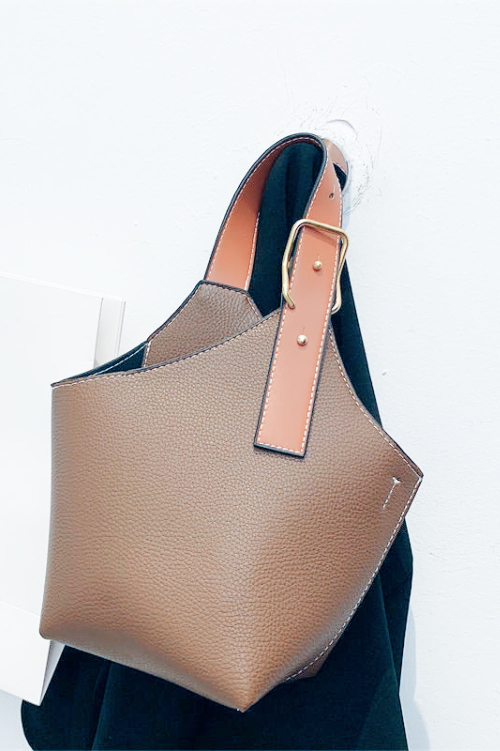 The Nandi Leather Bucket Bag in contrast pattern, showcasing its stylish design and compact size.