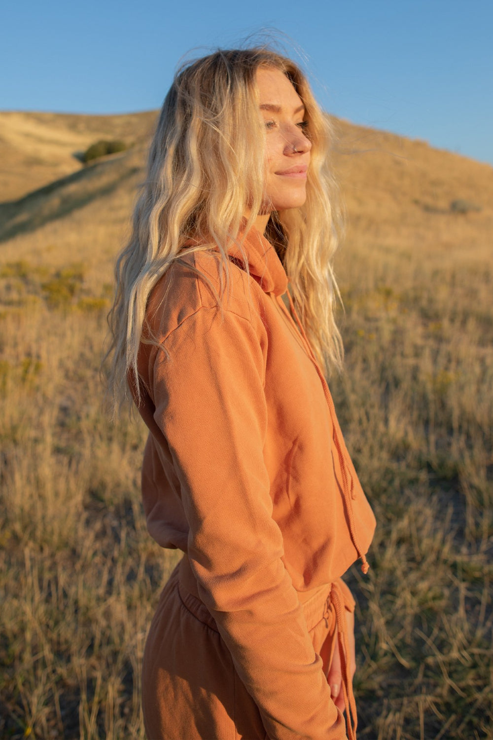 The New Daybreak Hoodie 2.0 in Apricot color, showcasing its relaxed fit and cropped design, perfect for casual wear.