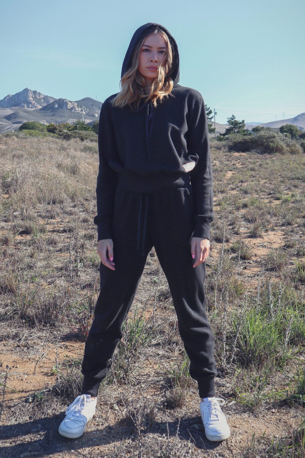 A pair of The New Daybreak Joggers in black, featuring a high waist, elastic ankle detail, and pockets, styled with a matching Daybreak Hoodie.