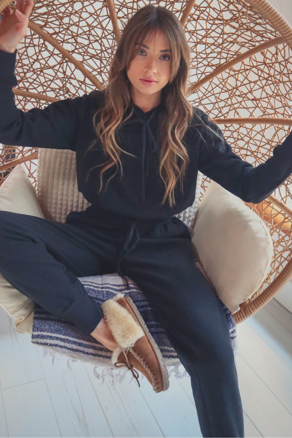 A pair of The New Daybreak Joggers in black, featuring a high waist, elastic ankle detail, and pockets, styled with a matching Daybreak Hoodie.