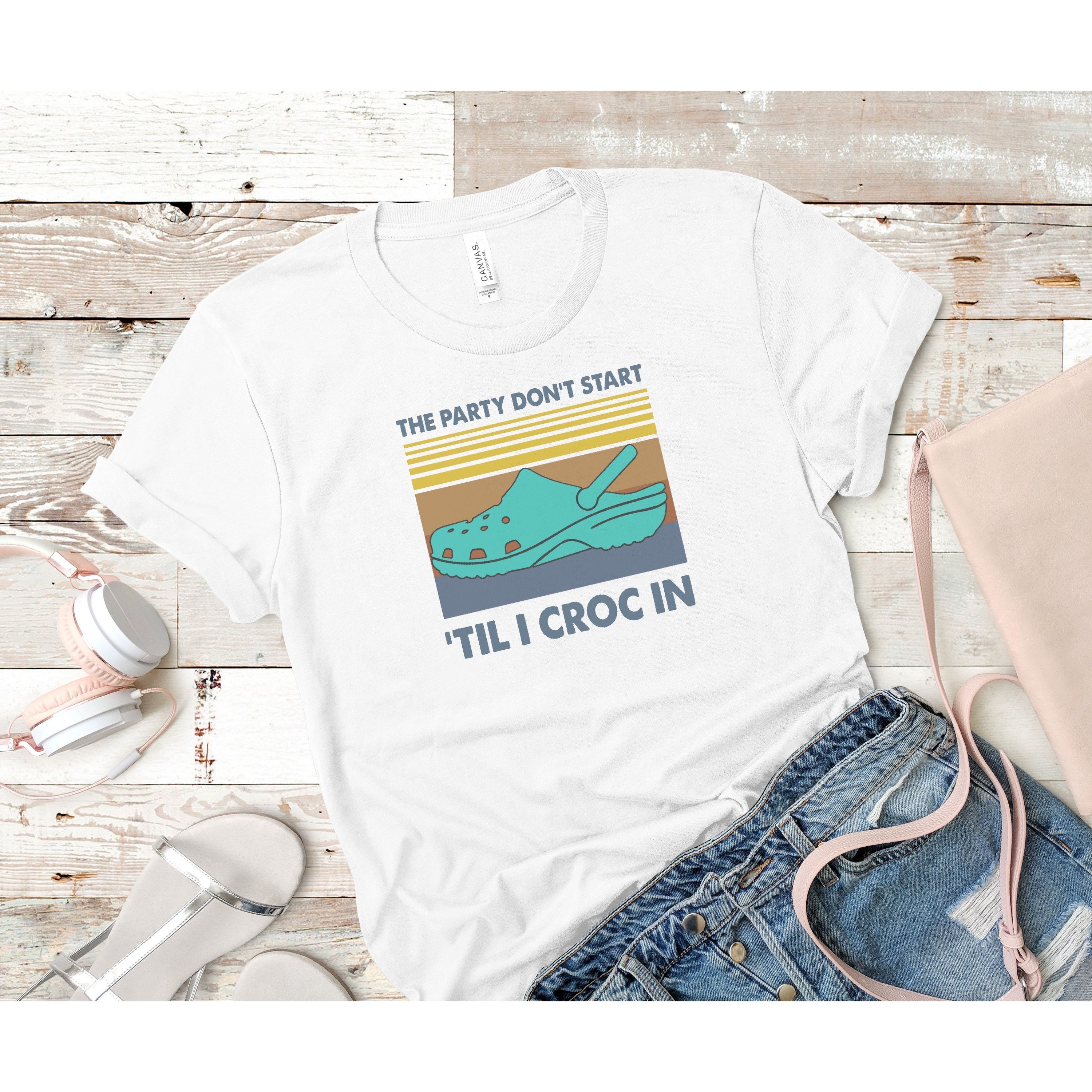 A vibrant retro tee featuring the phrase 'The Party Don’t Start 'Till I Croc In' designed for a fun and stylish look.