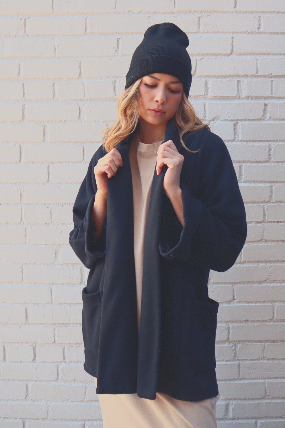 The Rumi layering piece in Washed Black, showcasing its soft fabric and relaxed fit, perfect for summer or cozy wear.