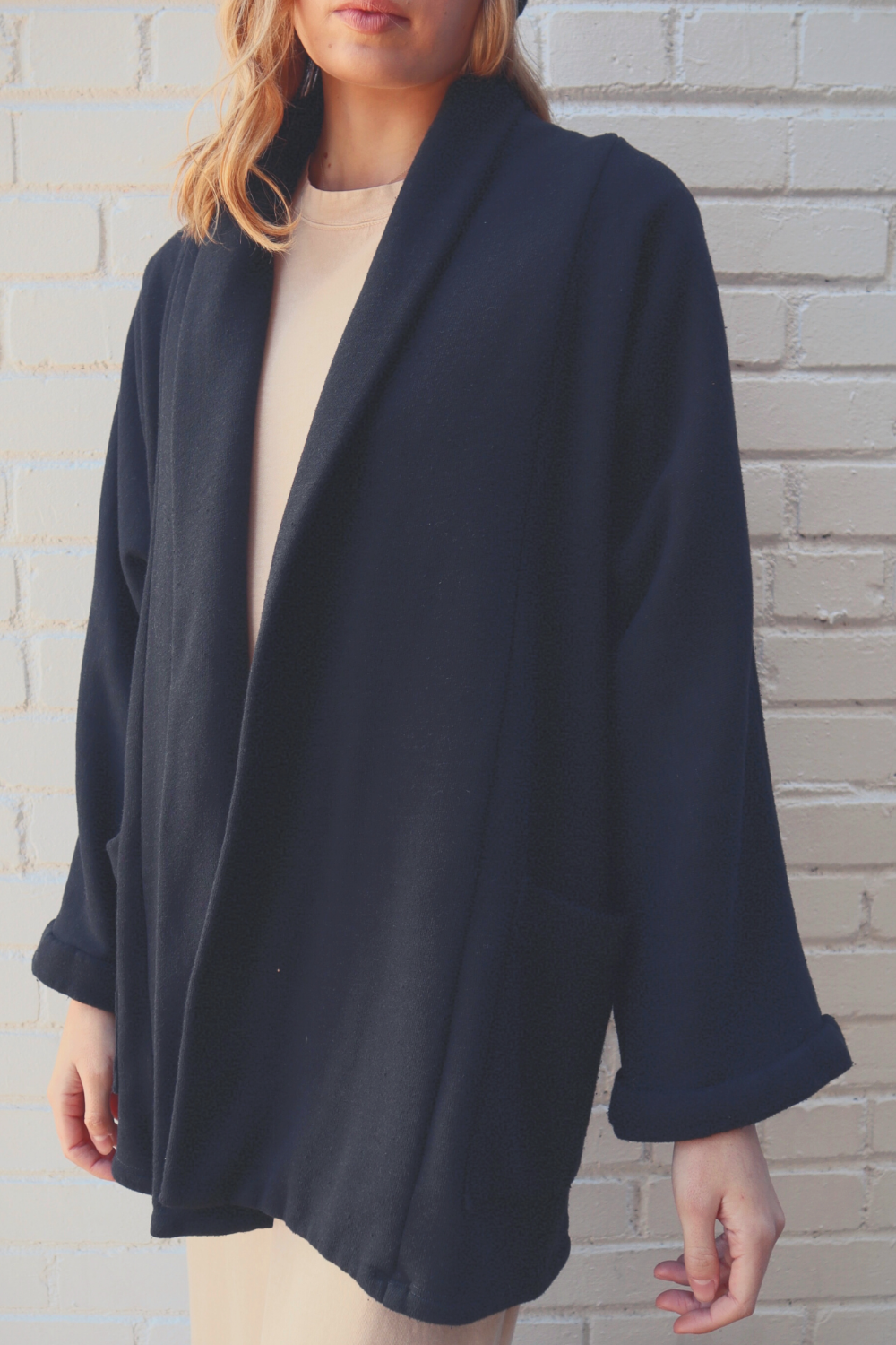 The Rumi layering piece in Washed Black, showcasing its soft fabric and relaxed fit, perfect for summer or cozy wear.