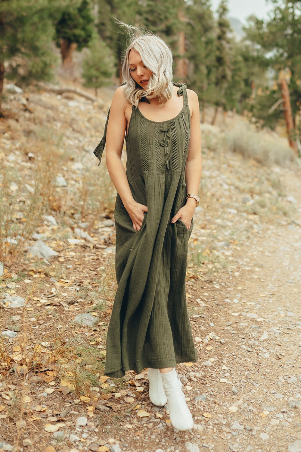 The Saguaro Dress in olive green with spaghetti straps, featuring a maxi length and pockets, perfect for beach outings.