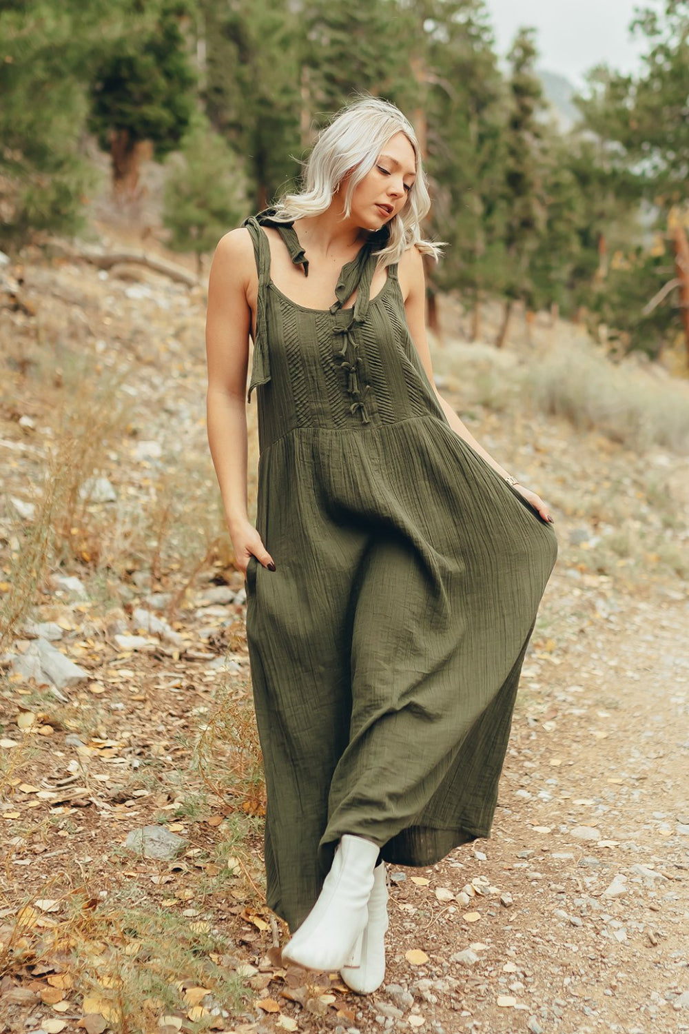 The Saguaro Dress in olive green with spaghetti straps, featuring a maxi length and pockets, perfect for beach outings.