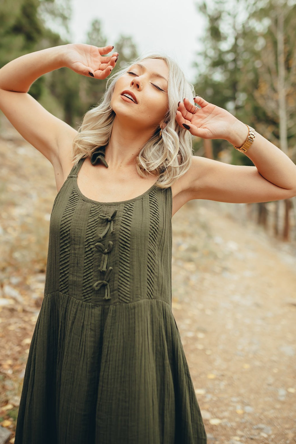 The Saguaro Dress in olive green with spaghetti straps, featuring a maxi length and pockets, perfect for beach outings.