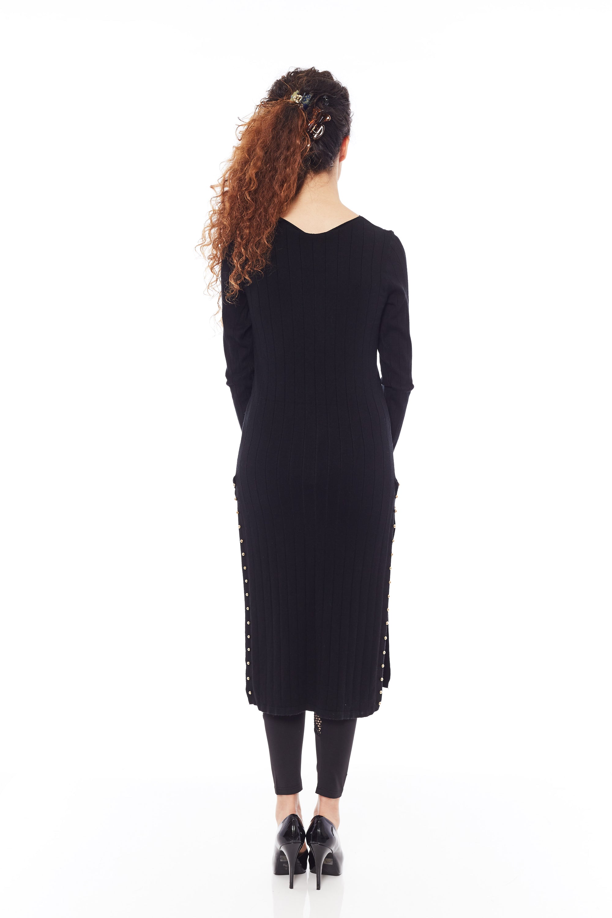 A stylish black sweater with long sleeves and side splits, showcasing its soft fabric and modern design.